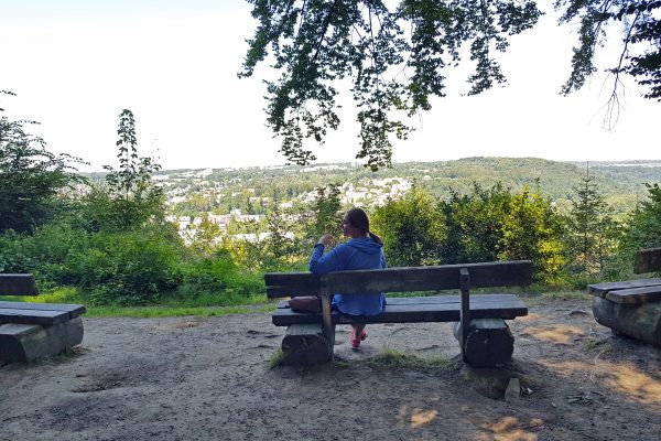 Das Foto zeigt Melissas Schwester an einem Rastplatz auf dem Kettwiger Panoramasteig mit Blick auf Essen