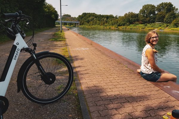 Das Foto zeigt Christin mit Fahrrad am Rhein-Herne-Kanal