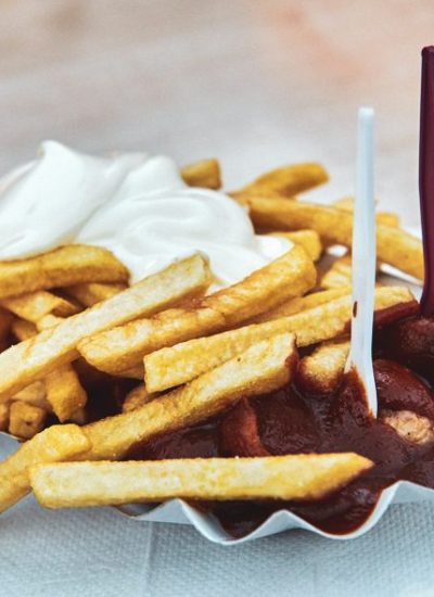 Das Bild zeigt Currywurst und Pommes