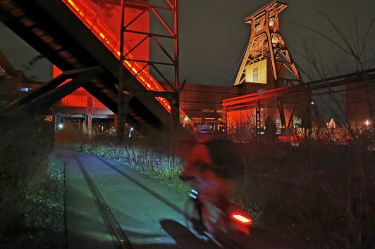 Das Foto zeigt einen Radfahrer bei einem Nightride durchs Ruhrgebiet auf dem Gelände der Zeche Zollverein