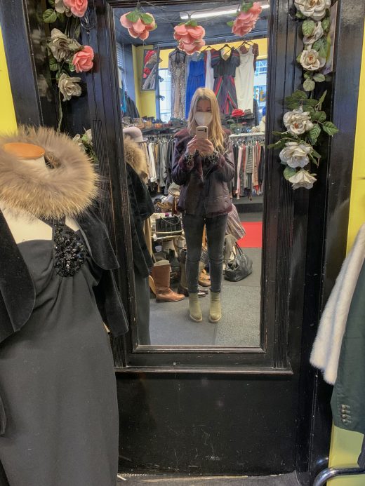Das Foto zeigt Leonie mit Second Hand Jacke vorm Spiegel im Second Hand Laden MISFITS in Bochum