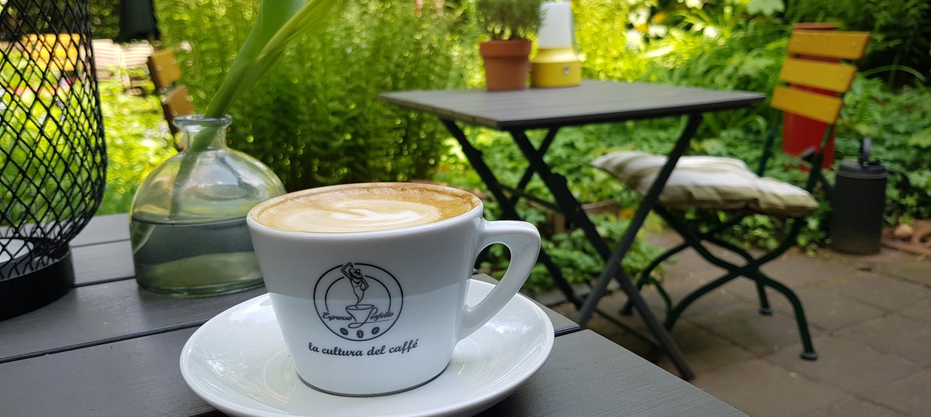 Das Foto zeigt einen Cappuccino im Hinterhof des WinzigSchön in Duisburg