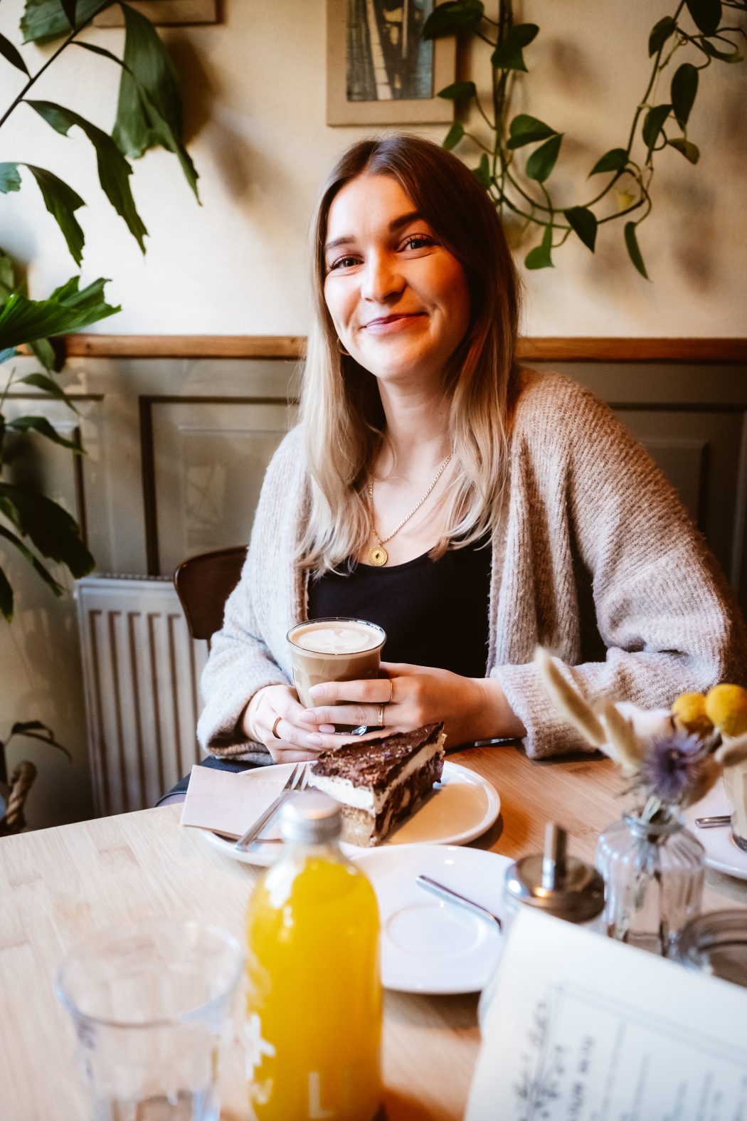 Das Bild zeigt eine Person mit Kaffee und Kuchen im das Kaff in Mülheim an der Ruhr