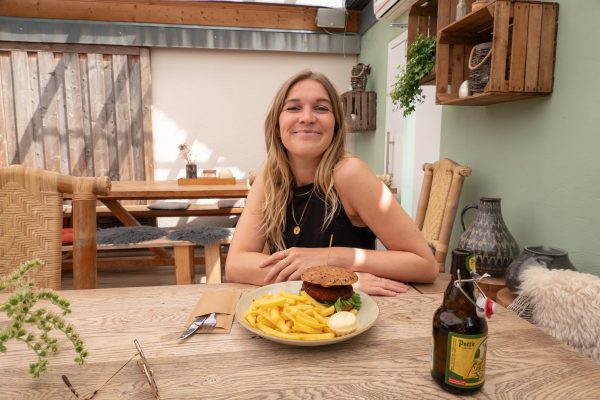 Das Foto zeigt Leonie mit ihrem Burger im Restaurant die farm in Essen