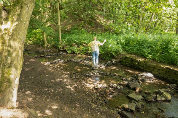 Das Foto zeigt Katalina an einem Bach im Stadtwald in Essen-Kettwig