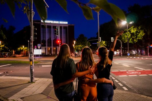 Das Foto zeigt Eileen, Leonie und Christin nachts am Schauspielhaus Bochum