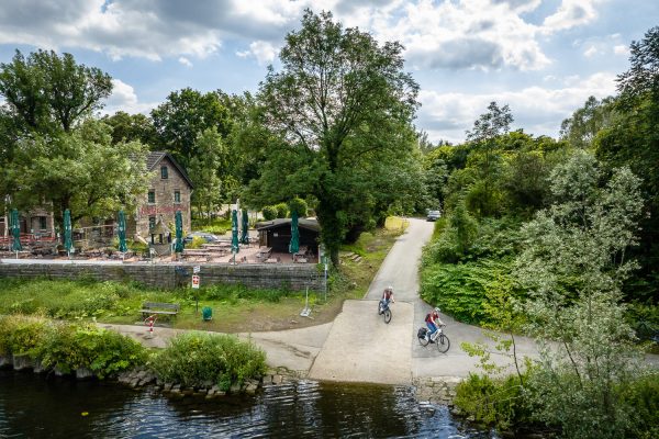 Das Foto zeigt Radfahrer auf dem RuhrtalRadweg am Fährhaus Rote Mühle in Essen