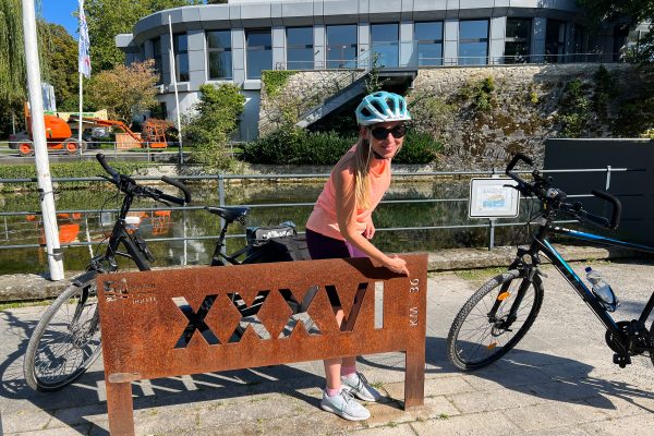 Das Foto zeigt Sandra an einer Kilometertafel auf der Römer-Lippe-Route